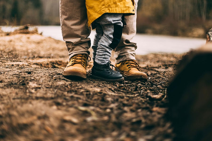 an image of a young boy's shoes as learns to walk with his father
